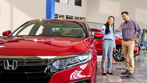 image of 2 people pointing at a car