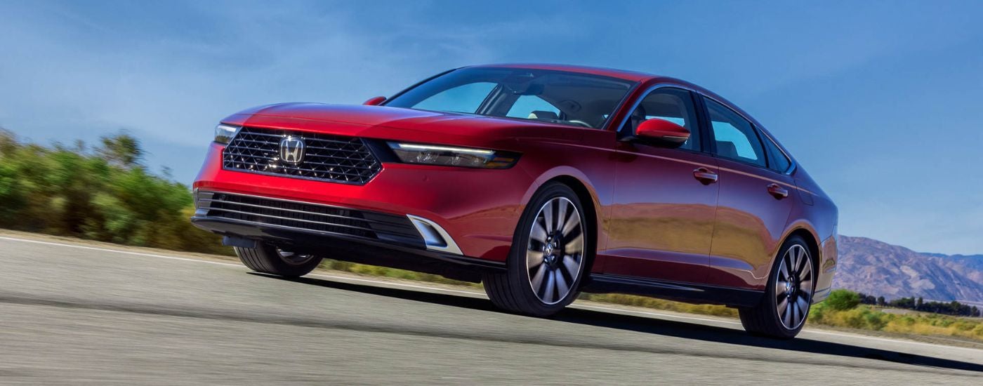 Red 2023 Honda Accord driving on a highway