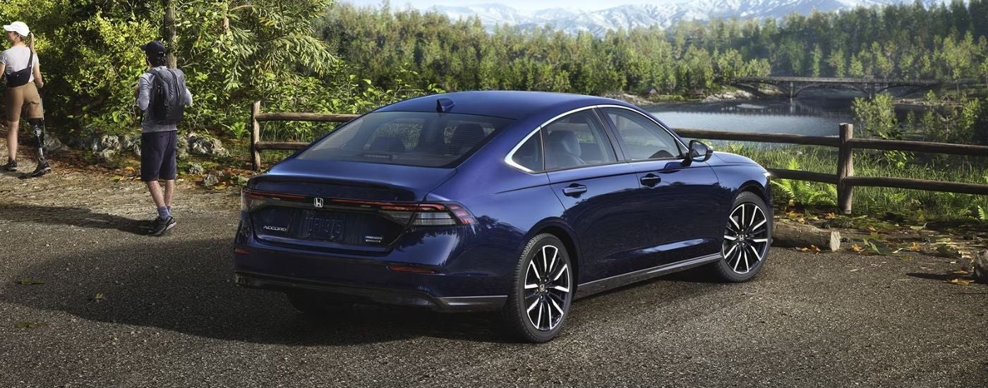 A blue 2026 Honda Accord rear view parked in front of a river.
