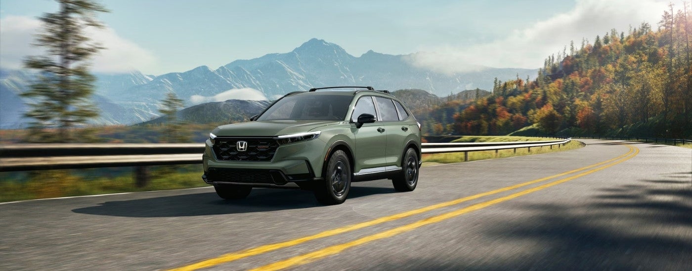 Green 2026 Honda CR-V Hybrid TrailSport driving on a highway