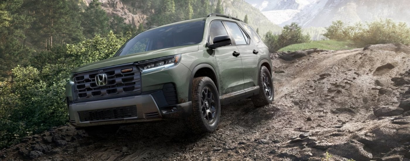 Green 2026 Honda Pilot TrailSport driving on a trail