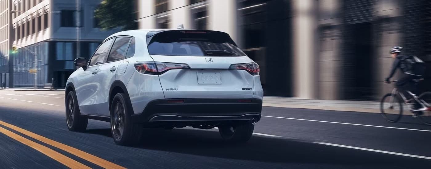 A white 2023 Honda HR-V Sport rear-view driving.