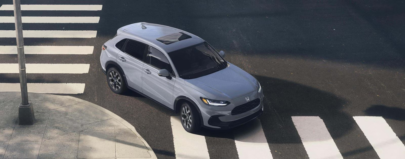 Gray 2027 HR-V turning a corner over a crosswalk.